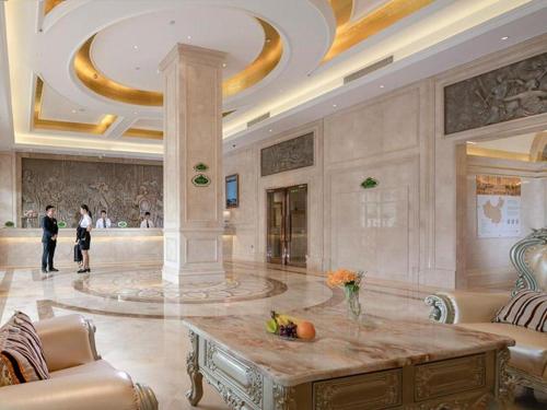 un gran vestíbulo con una mesa en el medio en Vienna Hotel Shenzhen Henggang Metro Station en Bingkeng
