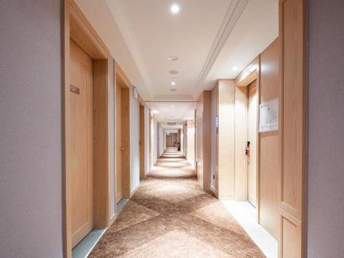 a corridor of a hallway with a long hallway at Vienna Hotel Chongqing Wushan Municipal Government in Wushan