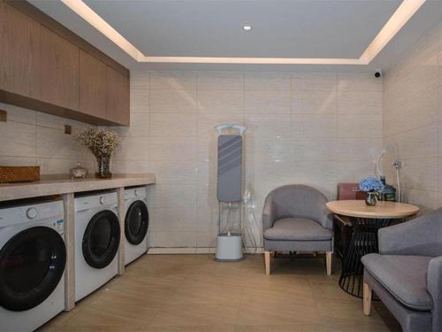 lavadero con lavadora, mesa y silla en Vienna Hotel Kunming Dashanghui, en Kunming