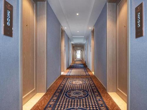 korytarzem z podłogą wyłożoną kafelkami w budynku w obiekcie Vienna Hotel Kunming Dashanghui w mieście Kunming
