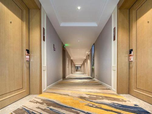 an empty hallway with a carpet on the floor at Vienna Hotel Tianjin Binhai New District Ocean High-Tech Zone in Binhai