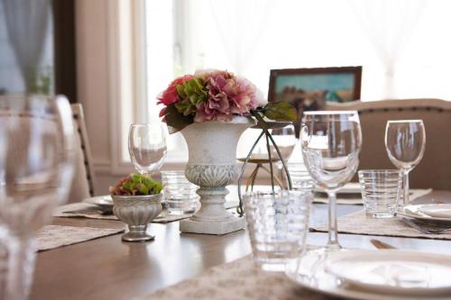 a table with glasses and a vase with flowers on it at 東海岸の美しい海が見える!ラグジュアリーな大豪邸！ in Uruma