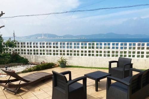 a patio with chairs and tables in front of a building at 東海岸の美しい海が見える!ラグジュアリーな大豪邸！ in Uruma