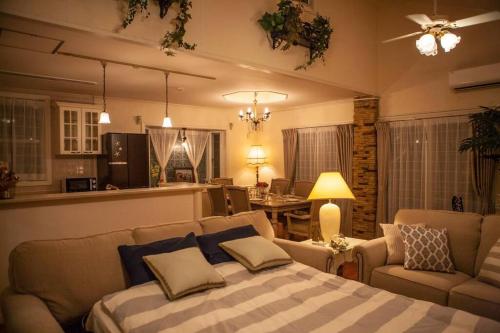 a bedroom with a bed and a couch and a kitchen at 東海岸の美しい海が見える!ラグジュアリーな大豪邸！ in Uruma