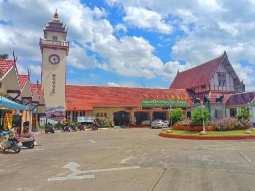 eine Stadt mit einem Uhrturm in der Mitte einer Straße in der Unterkunft RoomQuest Chiang Mai Tha Sala in Chiang Mai