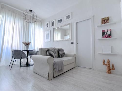 a white living room with a white couch and a table at The Boutique Houses Milan - Navigli in Milan