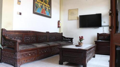 een woonkamer met een bank en een flatscreen-tv bij Amarta Malioboro By Daphna International in Yogyakarta
