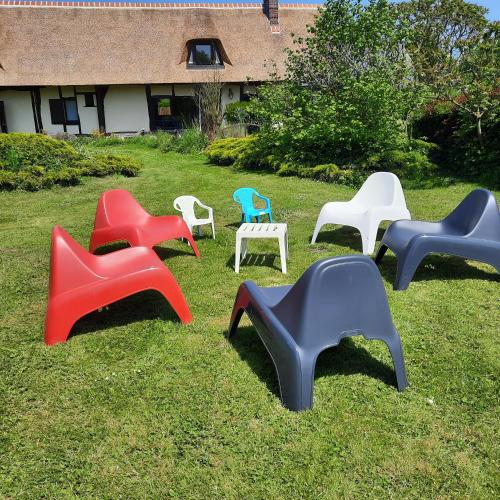 a group of chairs sitting in the grass at Les 2 chaumières avec piscine in Épinay