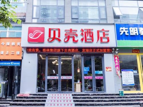 un edificio con un cartel en la parte delantera en Shell Hotel Xinzheng Longhu Town Xiang'an Road, en Guodian