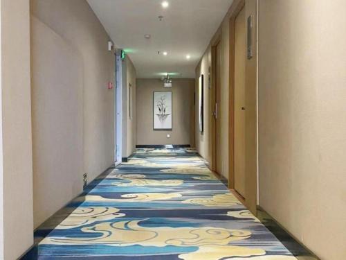 a hallway with a colorful carpet on the floor at Shell Hotel Xinzheng Longhu Town Xiang'an Road in Guodian