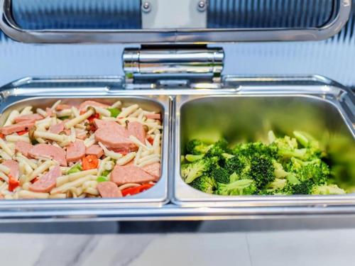 two trays of food with meat and broccoli at Borrman Hotel Chongqing Bishan Central Street in Chongqing