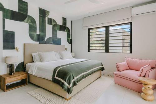 a bedroom with a bed and a pink couch at Tamarin Sunset Beach IV in Tamarin