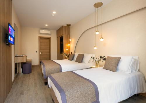 a hotel room with two beds and a flat screen tv at Ema Houses in Antalya