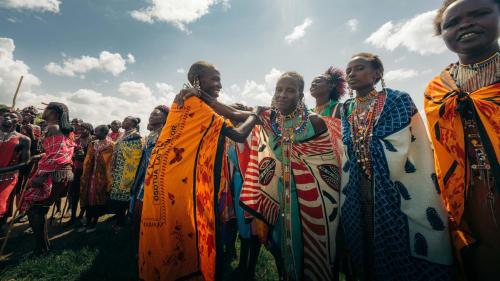 a group of people standing in a field at Emboo River Camp in Talek