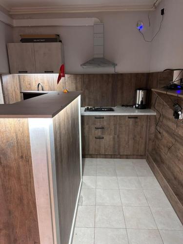a kitchen with wooden cabinets and a counter top at Holy Moly Hostel in Bishkek