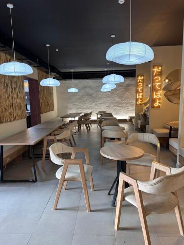 Holy Moly Hostel في بيشكيك: مطعم بطاولات خشبية وكراسي واضاءات