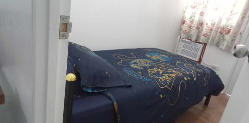 a bedroom with a blue bed with a dragon blanket at Condotel 2 bedroom with terrace and free car parking in Naga