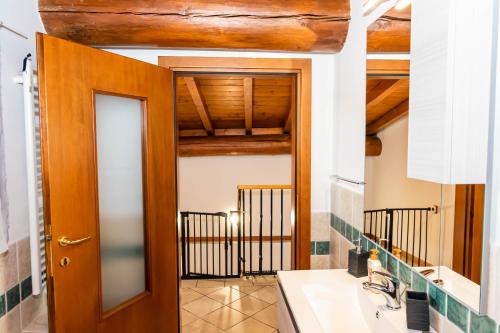 a bathroom with a wooden door and a sink at Casa Vacanza al Vecchio Ponte 