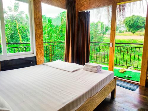 ein Schlafzimmer mit einem Bett und einem großen Fenster in der Unterkunft Moc Villa - Venuestay in Hanoi