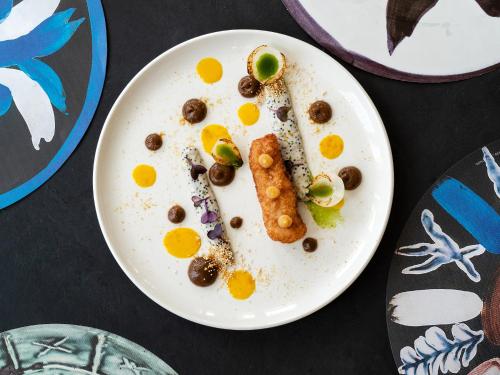 a white plate with food on a table at Amirandes, A Grecotel Resort to Live in Gouves