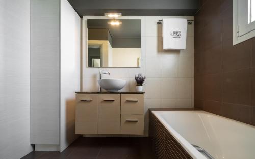 ein Badezimmer mit einem Waschbecken und einer Badewanne in der Unterkunft Elliniko Luxury Residence in Athen
