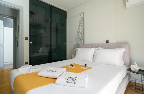 アテネにあるElliniko Luxury Residenceのベッドルーム1室(白い大型ベッド1台、白い枕2つ付)