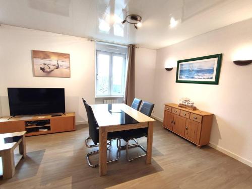 a living room with a table and a television at Appartement au centre de TREBEURDEN et à 500m de la plage - Ref 665 in Trébeurden
