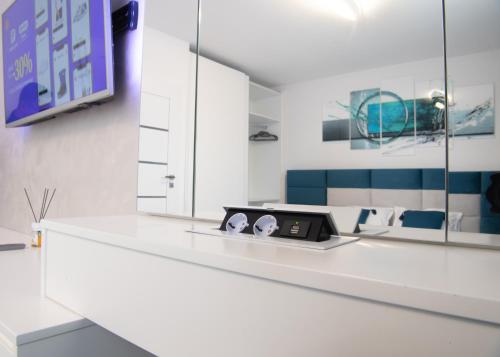 a white kitchen with a white counter top and mirrors at Oltenia Studio Happy Residence Craiova in Craiova