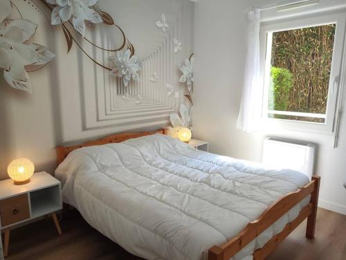 Un dormitorio con una cama grande y una ventana en Appartement avec WIFI, terrasse, jardin à TREBEURDEN Réf - 678 en Trébeurden