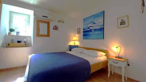 1 dormitorio con 1 cama con manta azul y ventana en Apartments Donda, en Split
