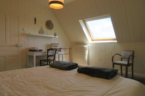 une chambre avec un lit avec deux oreillers dessus dans l'établissement Maison de charme à 600m de la mer avec WIFI à PLEUMEUR - BODOU REF-648, à Pleumeur-Bodou