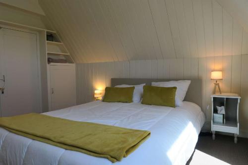 a bedroom with a large white bed with two green pillows at Maison de charme à 600m de la mer avec WIFI à PLEUMEUR - BODOU REF-648 in Pleumeur-Bodou