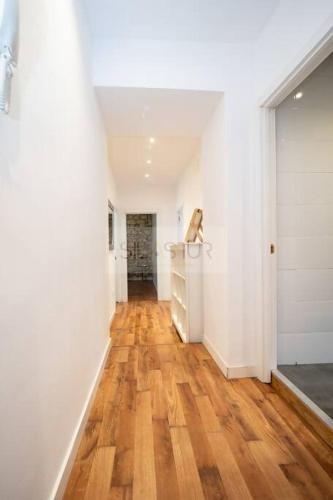 a hallway with white walls and a wooden floor at Vive Oviedo II Apartamento in Oviedo