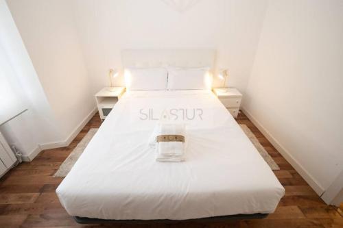a bedroom with a white bed with a sign on it at Vive Oviedo II Apartamento in Oviedo