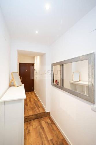a hallway with white walls and a wooden floor at Vive Oviedo II Apartamento in Oviedo