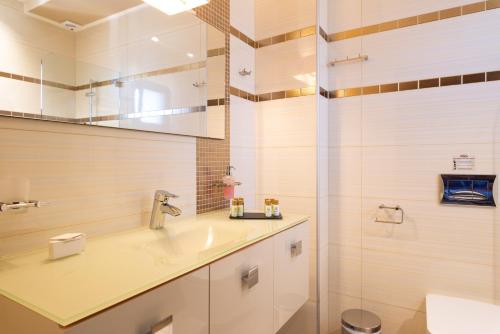 a bathroom with a sink and a shower at Sivota Diamond Spa Resort in Sivota