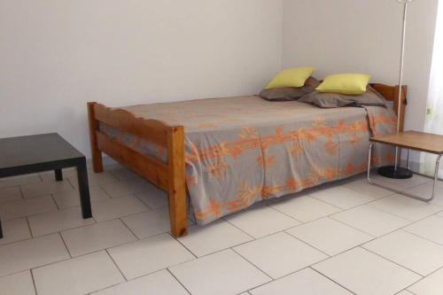 - une chambre avec un lit doté d'oreillers jaunes et d'une table dans l'établissement Appartement confortable à Marseille 21 m² avec terrasse calme, à Marseille