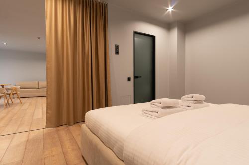 a bedroom with a white bed and a living room at SAVOIE Apartments Bukovel in Bukovel