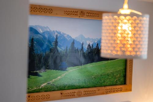 a picture of a painting of a green field at Pokoje na Równi Zakopane in Zakopane