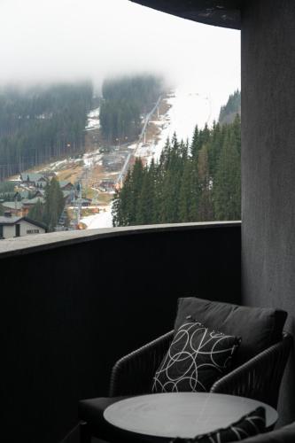 a room with a couch and a large window with a view at SAVOIE Apartments Bukovel in Bukovel