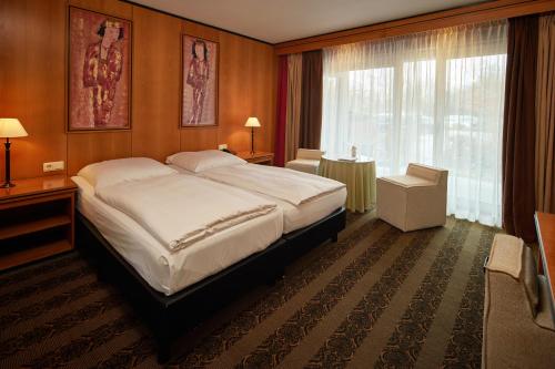 a bedroom with a large bed and a window at Hotel Gladbeck van der Valk in Gladbeck