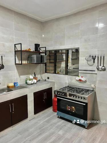 a kitchen with a stove and a counter top at RÉSIDENCES ORI in Cotonou