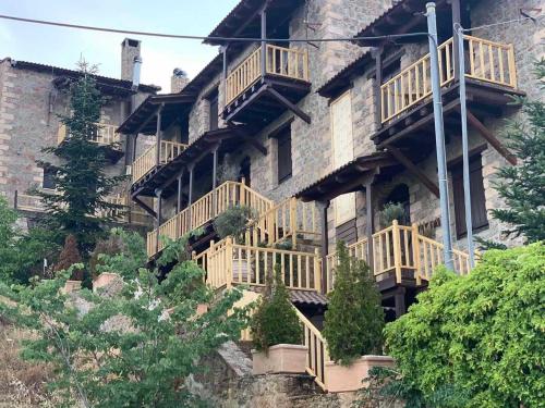 a building with wooden balconies on the side of it at Nymfes Guesthouse in Synikia Mesi Trikalon
