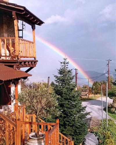 a rainbow in the sky over a house at Nymfes Guesthouse in Synikia Mesi Trikalon