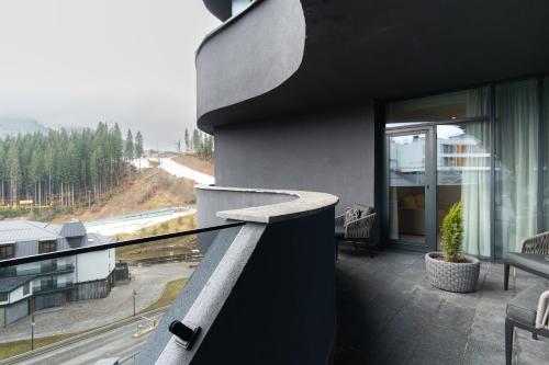 a balcony of a house with a view of a road at SAVOIE Apartments Bukovel in Bukovel