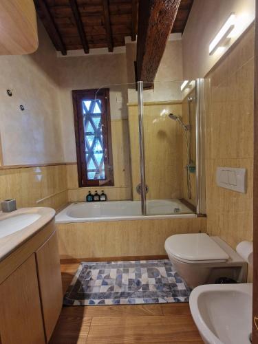 a bathroom with a tub and a toilet and a sink at Villetta dei Fagiani - B&B in Montauto