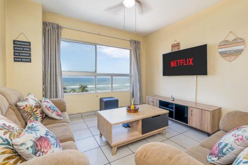 a living room with two couches and a tv at Amanzi402 Oceanview Retreat in Amanzimtoti