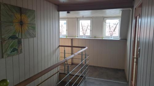 a staircase in a room with two windows at Ferienhaus „Zum alten Fröhlich“ in Dresden
