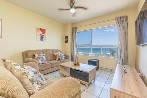 a living room with a couch and a table and a window at Amanzi402 Oceanview Retreat in Amanzimtoti