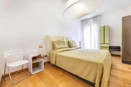 een witte slaapkamer met een bed en een stoel bij Trilocale Corso Italia 24 piano terra con spazio esterno in Gallipoli